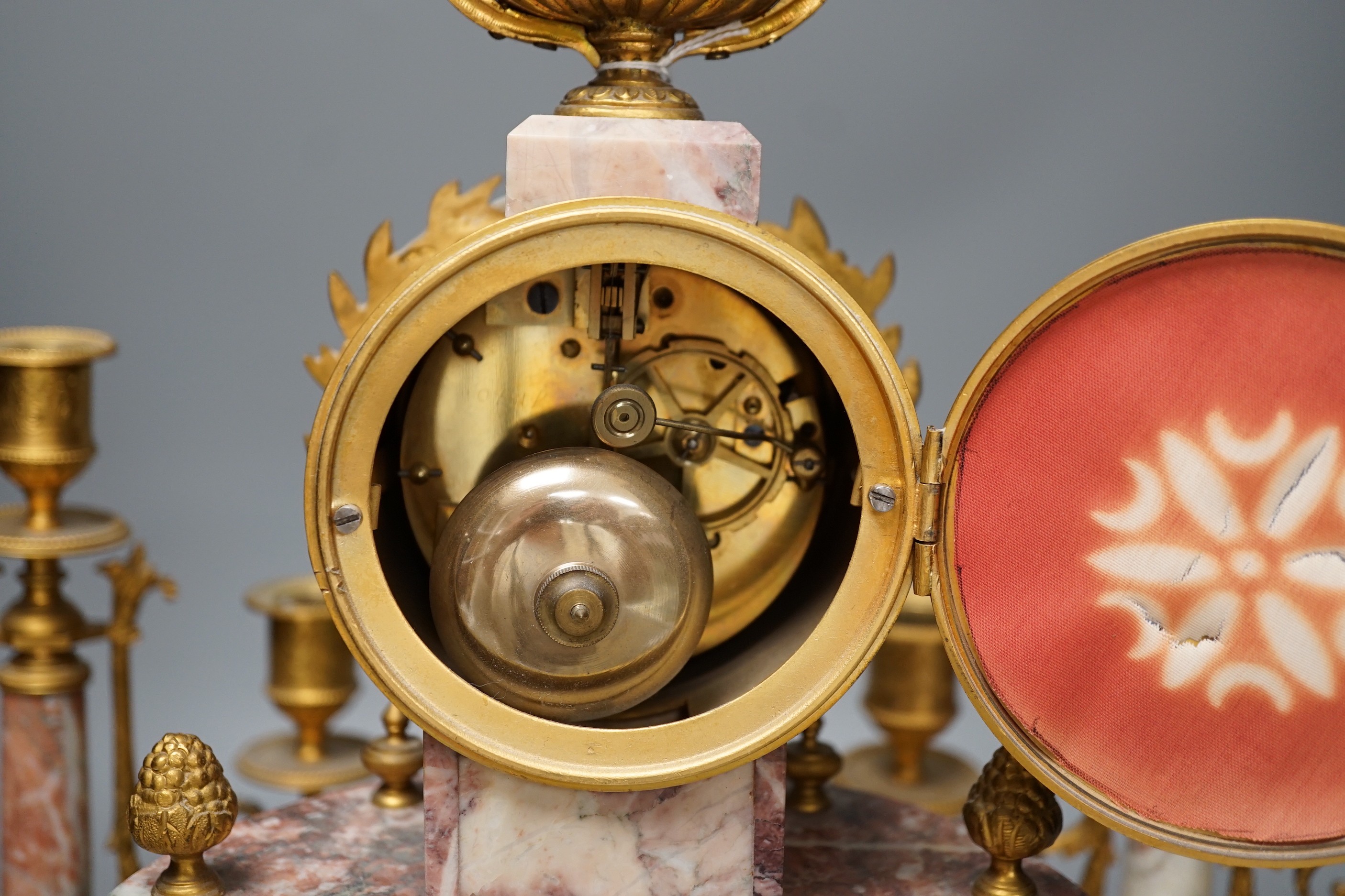 A French ormulu and rouge marble clock garniture, c.1900, with decorative enamel dial, 40cms high.